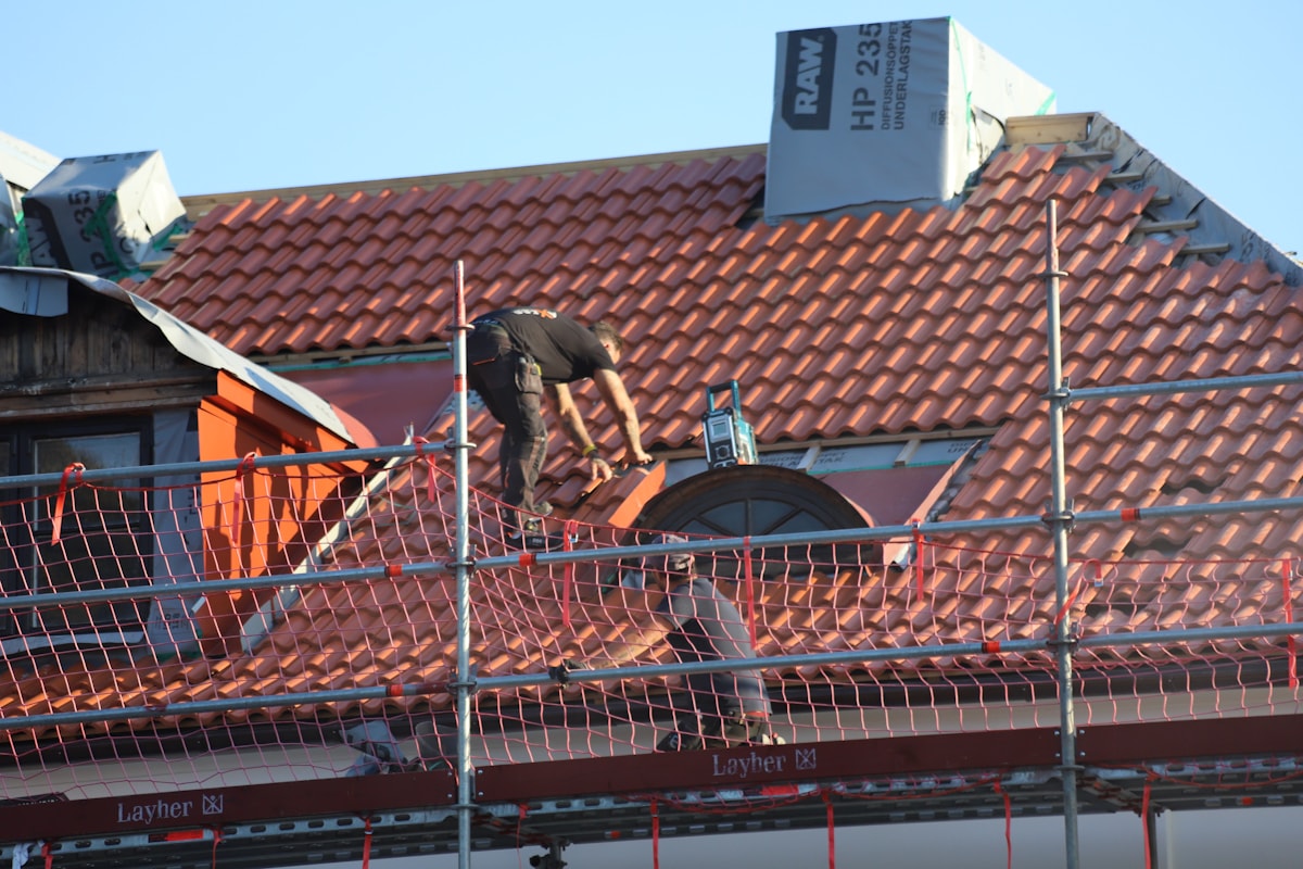 Roofing professionals working safely on a residential roof